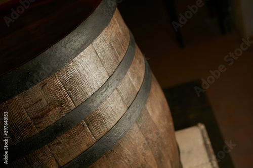 wooden barrel on a dark background, in a workshop, in an old room. production of barrels for cognac and wine, in a low key
