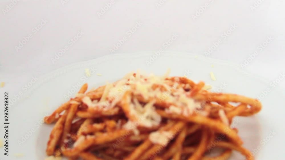 reverse flying over a plate of bucatini amatriciana with a drop of pecorino cheese reverse flying over a plate of bucatini amatriciana with a drop of pecorino cheese