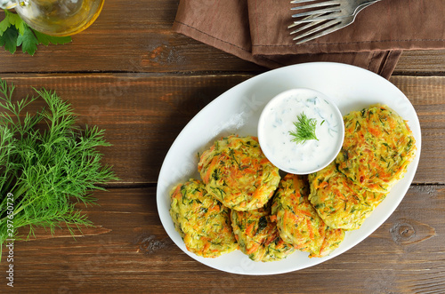Vegetable cutlet from zucchini, carrot, herbs on wooden table