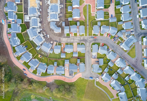 Suburban houses in row aerial view in summer illuminating gardens
