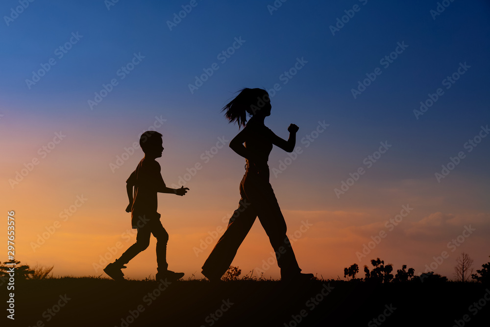 Silhouette woman and boy active walking at sky sunset.background
