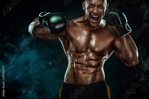 Sportsman, man boxer fighting in gloves on black background. Fitness and boxing concept. Action shoot. Individual sports recreation.