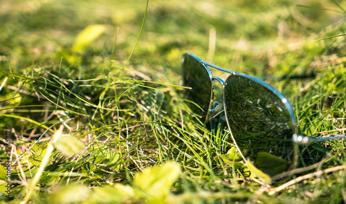 Sunglasses on the grass. The brilliance of the sky and the sun.