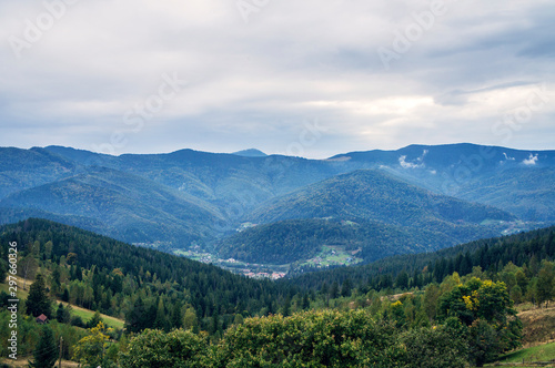 Beautiful autumn mountain forest landscape. Clouds over the blue rocks. © Payllik