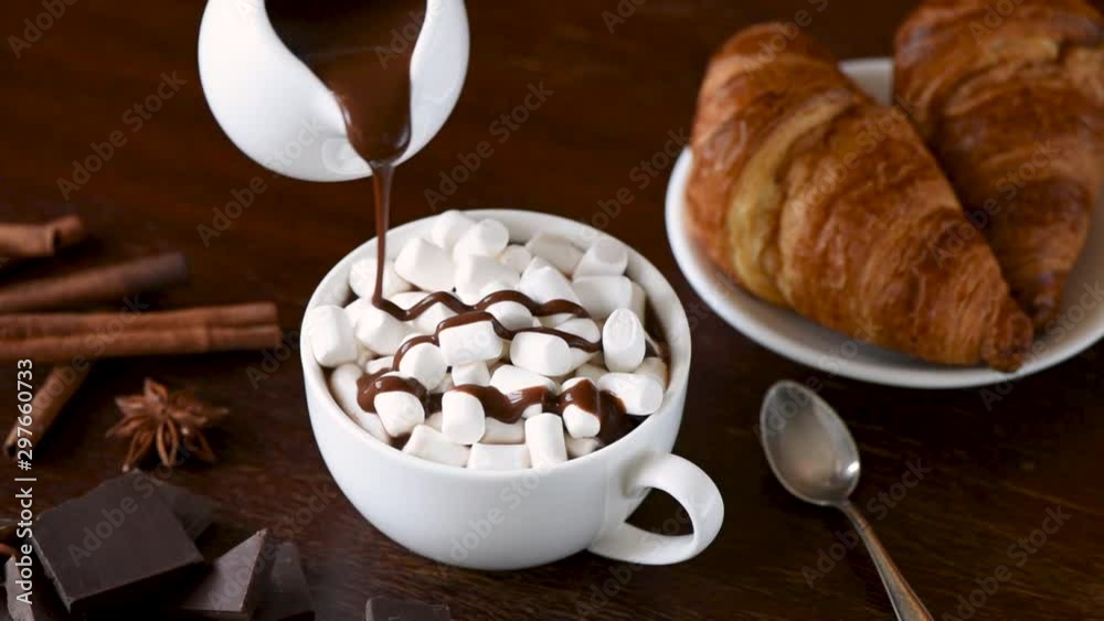 Hot chocolate with marshmallows. Slow motion of pouring chocolate sauce. Hot drink comfort food Hot chocolate with marshmallows. Slow motion of pouring chocolate sauce. Hot drink comfort food