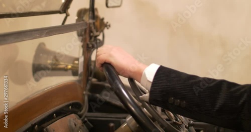 Man hands on a very old car steering wheel