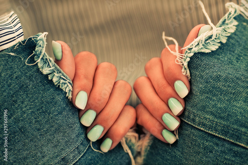 Close up nails with a gradient blue manicure on a jeans background. Top View photo