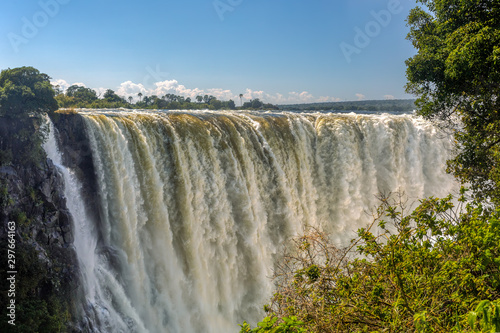Victoria falls after rain season in May, waterfall is full of water, everywhere is mist. Zambia Zimbabwe border, Africa wilderness landscape. Wonder of the World