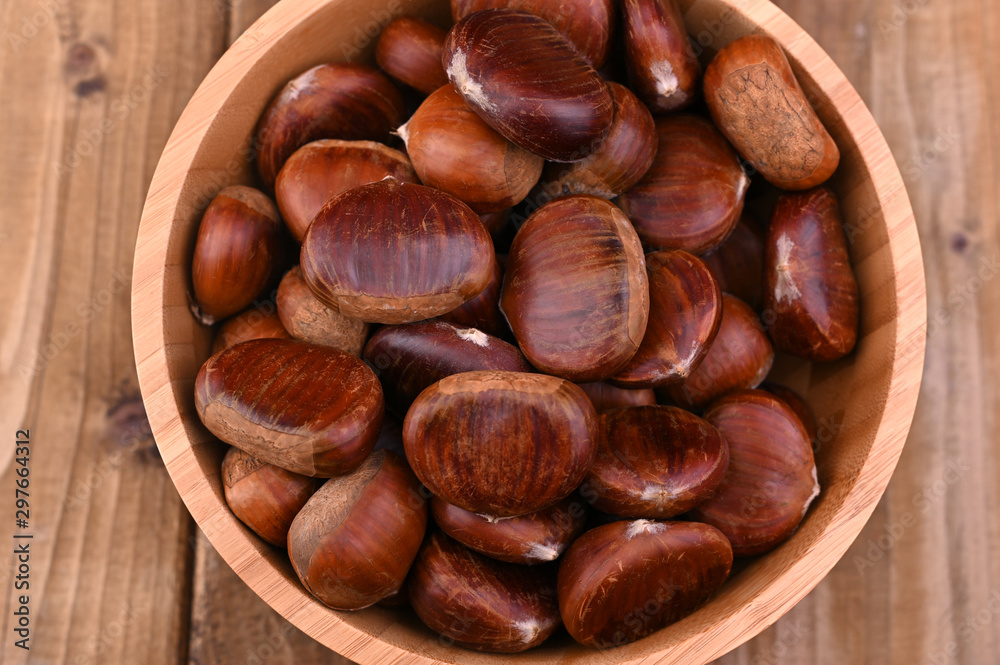 Cup of chestnuts on a wooden background. Autumn harvest and ripe fruits. Free space for text. Cup of chestnuts on a wooden background. Autumn harvest and ripe fruits. Free space for text.
