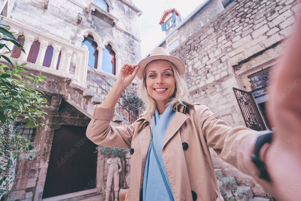 Tourism and technology. Traveling young woman taking selfie at Split old Town, Croatia.