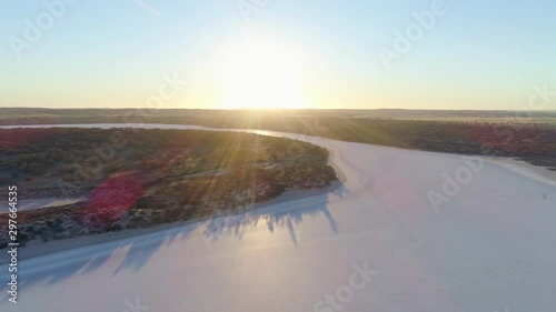 Flight across pink salt lake at sunrise in Australia photo