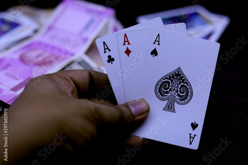 Hand holds three aces on a black background. Close up. photo