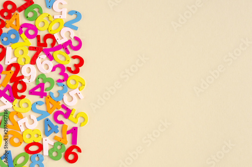 Colored wooden numbers composition on beige background.