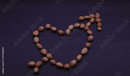 Valentine's day concept: Beautiful heart of the peanuts on the black background. Symbol of lovers.