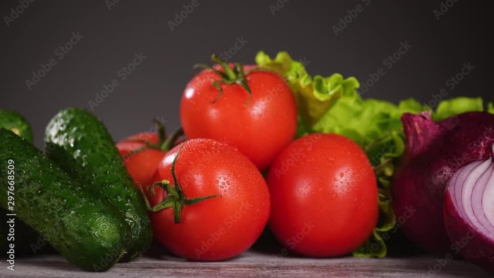Fresh vegetables on the wooden table. Focus is sliding, tomatoes apears from blur. Nobody in the frame.