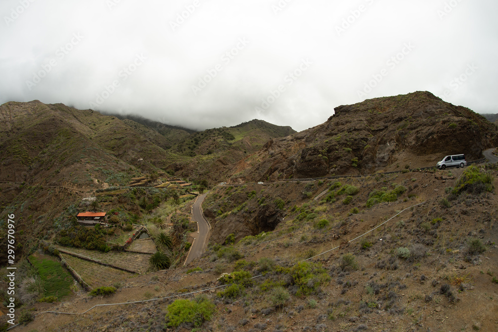 One of the tight turns of a narrow rural road in the mountains of Parque Natural Majona. View of Playa De Caleta the north-eastern part of La Gomera island. Canary Islands, Spain