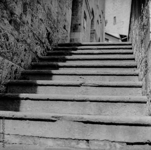 Fototapeta Naklejka Na Ścianę i Meble -  An old staircase among the narrow streets in the medieval town of Massa Marittima in Tuscany shot with analogue film technique