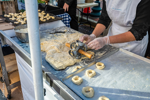 Canvas-taulu Amish women making fresh doughnuts by hand at outdoor market