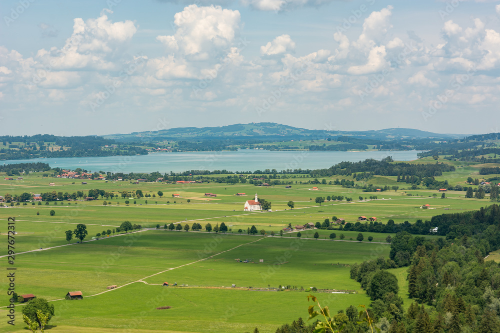 Obraz premium Panoramic view of riverland with green pastures and fields.