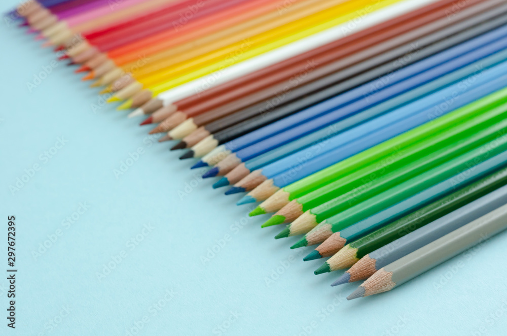 Colored pencils composition on blue background. Flat lay. Colored pencils composition on blue background. Flat lay.