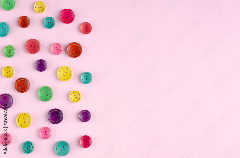 Obraz premium Colored sewing buttons composition on pink background.