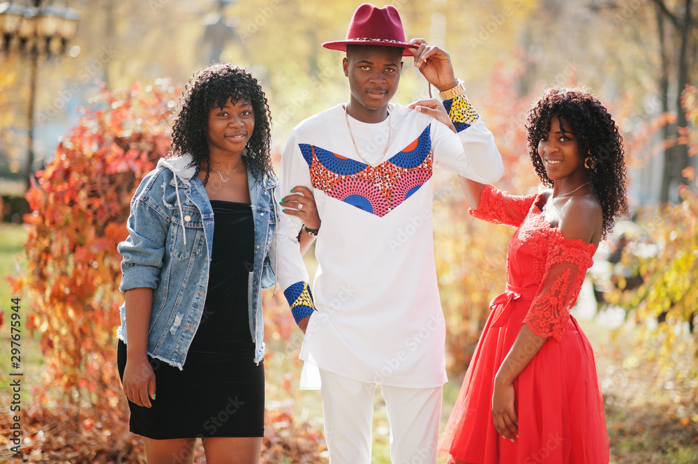 Group of three stylish trendy afro france friends posed at autumn day. Black african man model with two dark skinned womans.