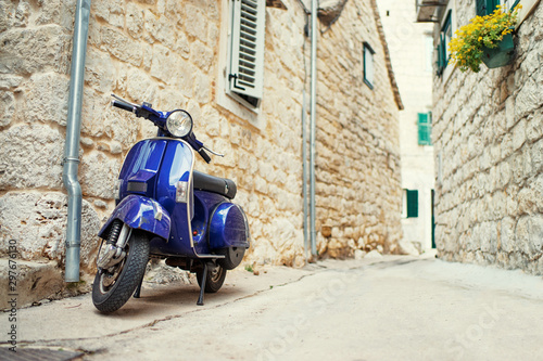 Motorbike outdoor. Blue retro style scooter on old town street.