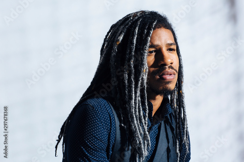 Canvas-taulu Portrait of a serious young man with cool dreadlocks hair isolated in studio