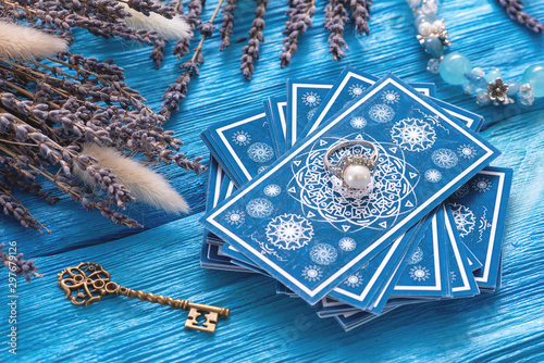 Blue tarot cards deck on blue wooden table background.