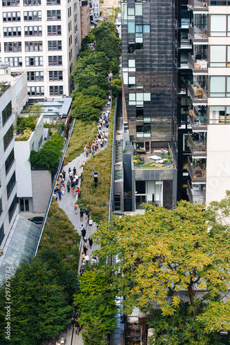 The New York High Line urban park aerial view, tourists walking, surrounded by tall buildings