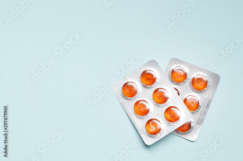 Two Blisters with color cough drops on a blue background..Medicine concept.