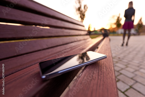 Naklejka Forgotten smartphone on a park bench.