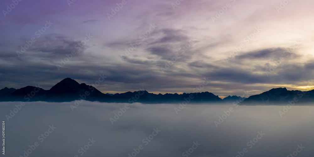 view over cloud bank to mountains of reutte valley at sunset dawn