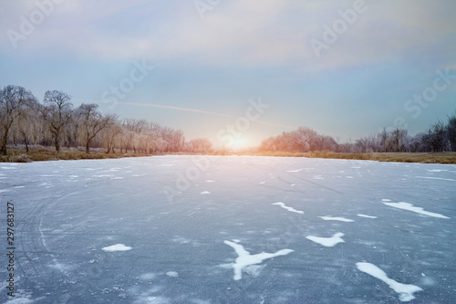 Fototapeta Naklejka Na Ścianę i Meble -  the sun over a frozen lake on a winter evening.