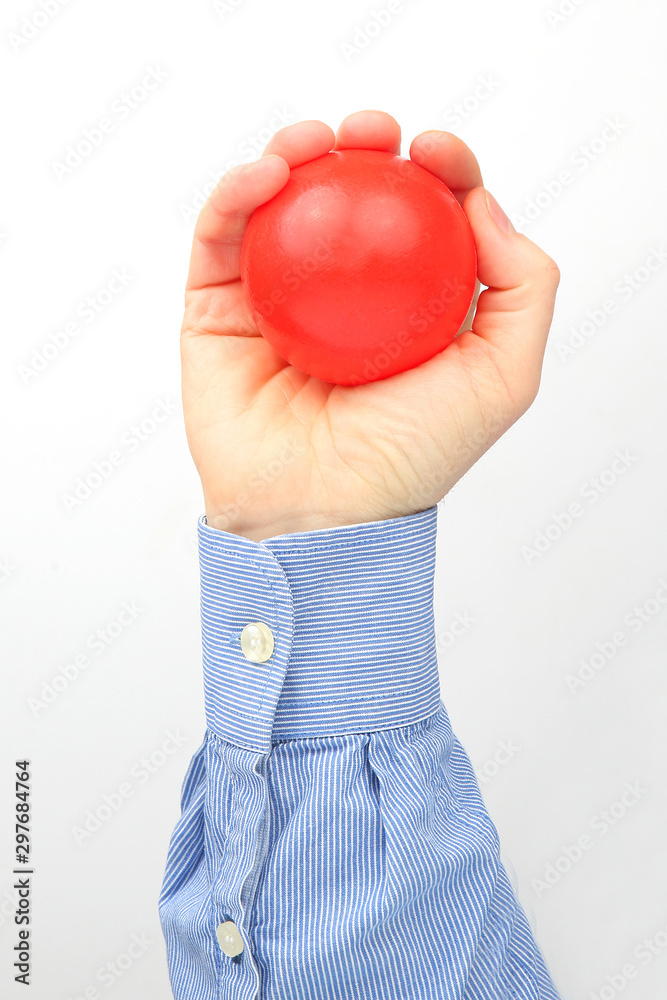 Male hand holds a red ball on a white background Male hand holds a red ball on a white background