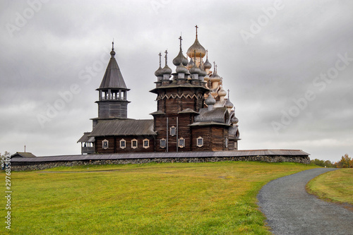 Karelia, Russia - august 27, 2019: Sunset landscape with view of the Transfiguration Church and farm house on the island of Kizhi, Karelia region, Russia in raining photo