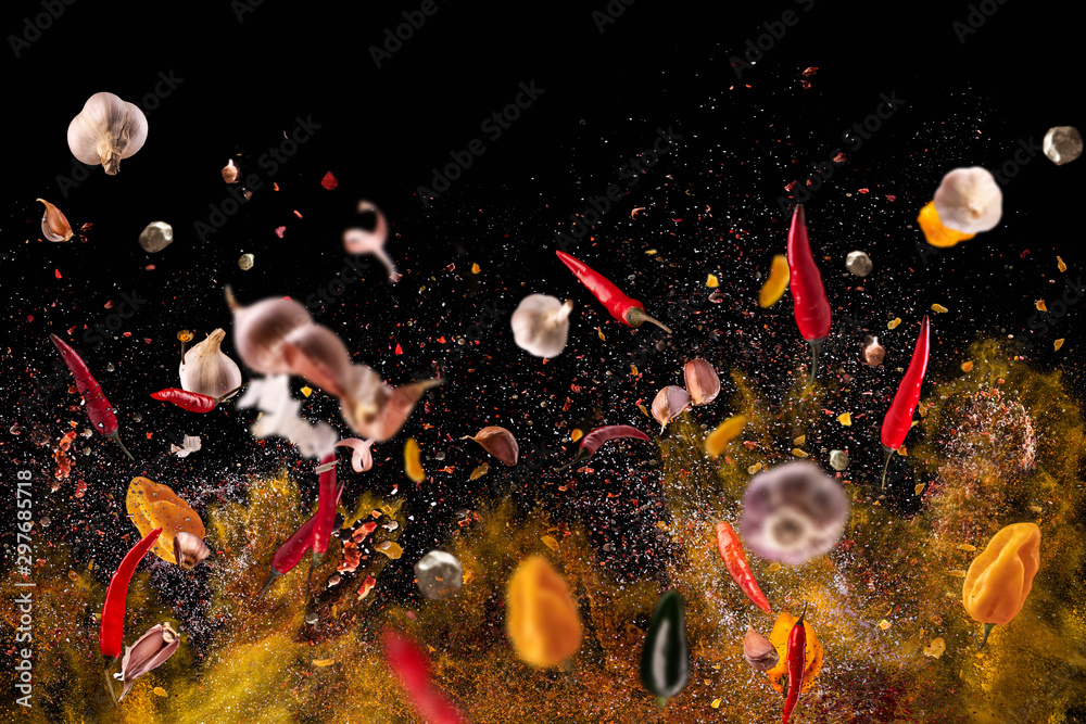 Hot red pepper, garlic, different spices powder meat stakes flying on a black background Motion freeze photo composition - obrazy, fototapety, plakaty 