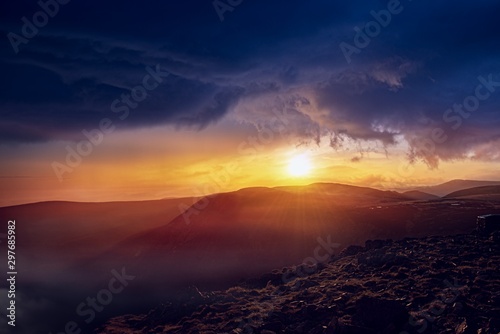 Stormy mountains landscape . Sun light through violent storm clouds. Weather in peas