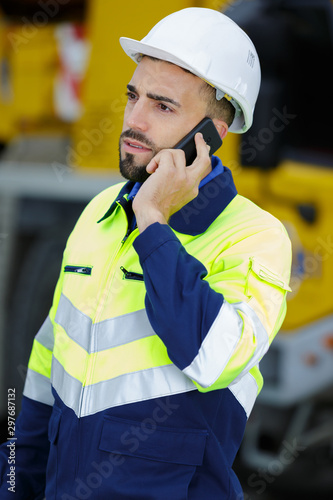 young male engineer at construction site using smart phone