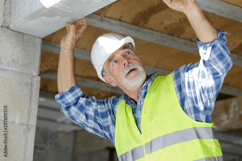 senior man inspecting lintel on construction site photo
