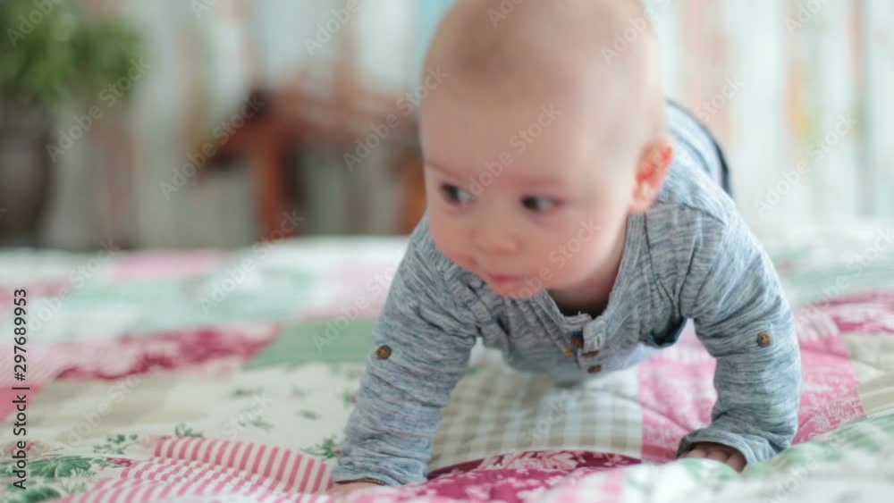 Baby boy, smiling happily, lying in bed, playing Baby boy, smiling happily, lying in bed, playing