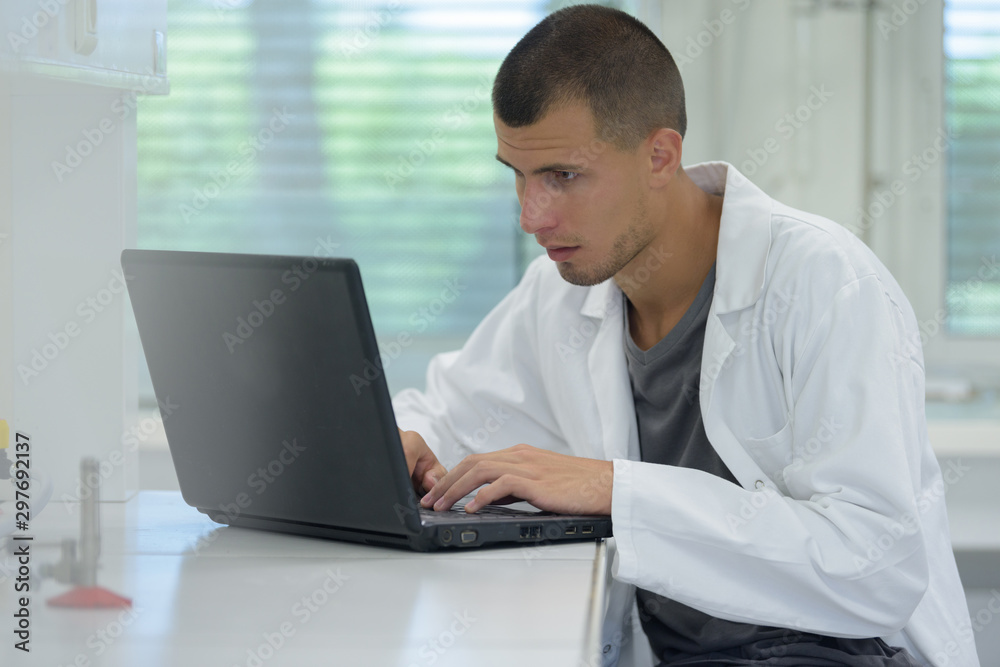 man student working in chemical lab on experiment man student working in chemical lab on experiment