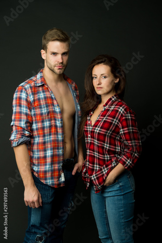 Family look. Similar outfits. Couple wear checkered shirts. Rustic hipster style. Handsome man and woman looking similar in family style clothes. Casual and comfortable. Family posing photo session