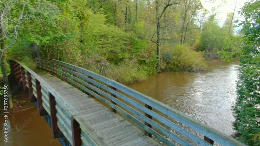 Flying over foot bridge, down stream, and out to vast lake at sunrise, time lapse. Flying over foot bridge, down stream, and out to vast lake at sunrise, time lapse.