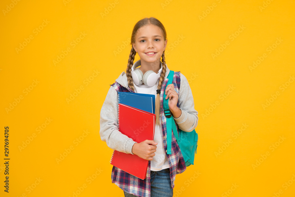 Hello school. Happy girl ready for school on yellow background. Little kid hold books and school bag. Small child back to school in autumn. Education and knowledge Hello school. Happy girl ready for school on yellow background. Little kid hold books and school bag. Small child back to school in autumn. Education and knowledge