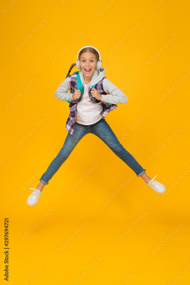 Energetic and enthusiastic. Energized small girl jump high with energetic power. Active kid back to school in energetic mood. Energetic little child in motion yellow background Energetic and enthusiastic. Energized small girl jump high with energetic power. Active kid back to school in energetic mood. Energetic little child in motion yellow background