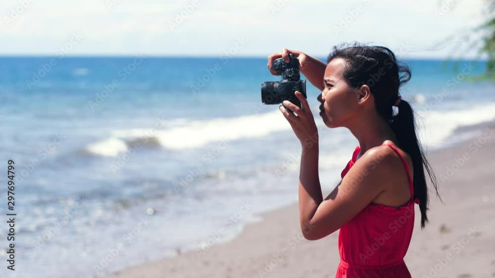 Clumsy woman amatuer photographer drop a DSLR camera on the beach. Clumsy woman amatuer photographer drop a DSLR camera on the beach.