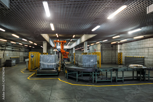 Tableau sur toile Robot Hand manipulator packaging factory products from conveyor into container