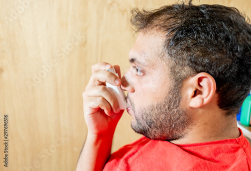 Arabic man taking his asthma medicine by mouth