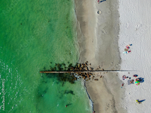 Aerial top view of Cortez white san beach and little rocks pier, Anna Maria Island, Florida, USA